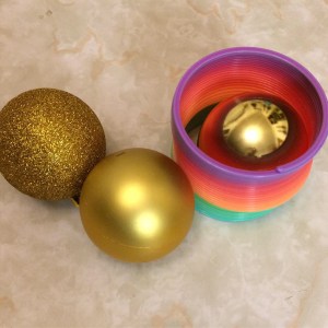 Rainbow Slinky toy and gold Christmas ornaments