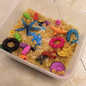 Sensory bin filled with rice, pasta, and toys